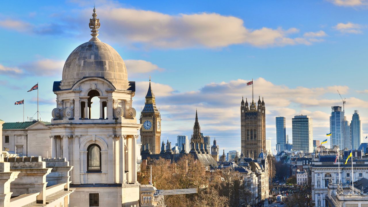 カーテンと鏡の前に白い大型バスタブがある、明るい光に囲まれた暗いバスルーム